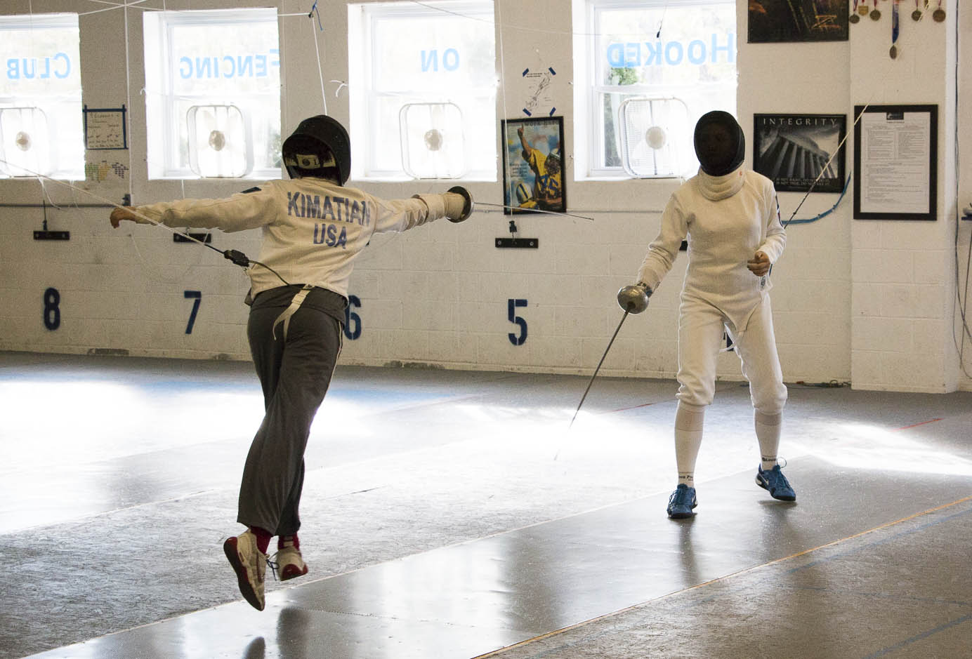 Fencer performing a fleche attack at Hooked on Fencing